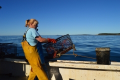 A woman fishes for lobster off the coast of Maine with her husband.